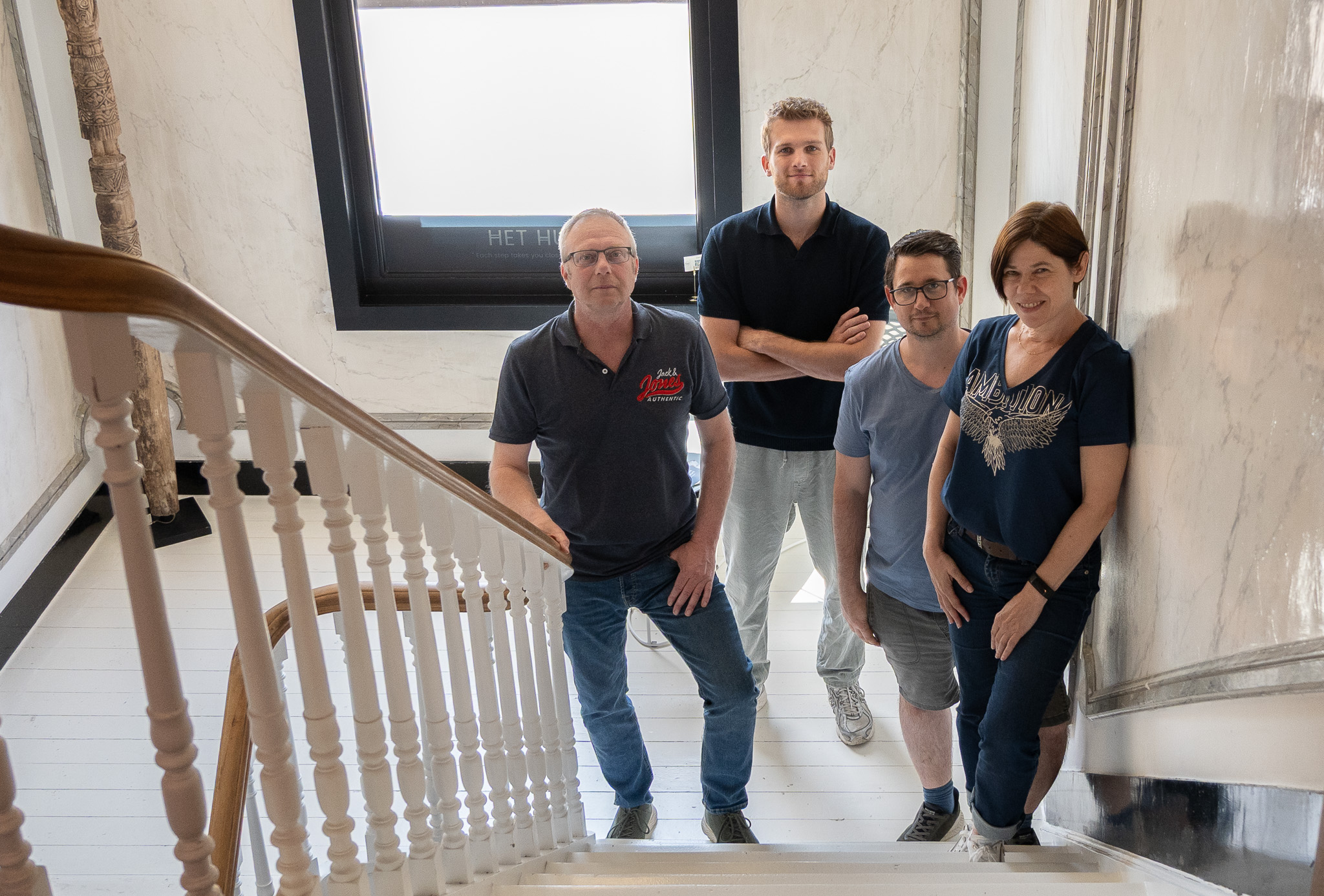 Mailbox-team in overleg rond een meetingtafel, laptop met website-ontwerp in zicht
